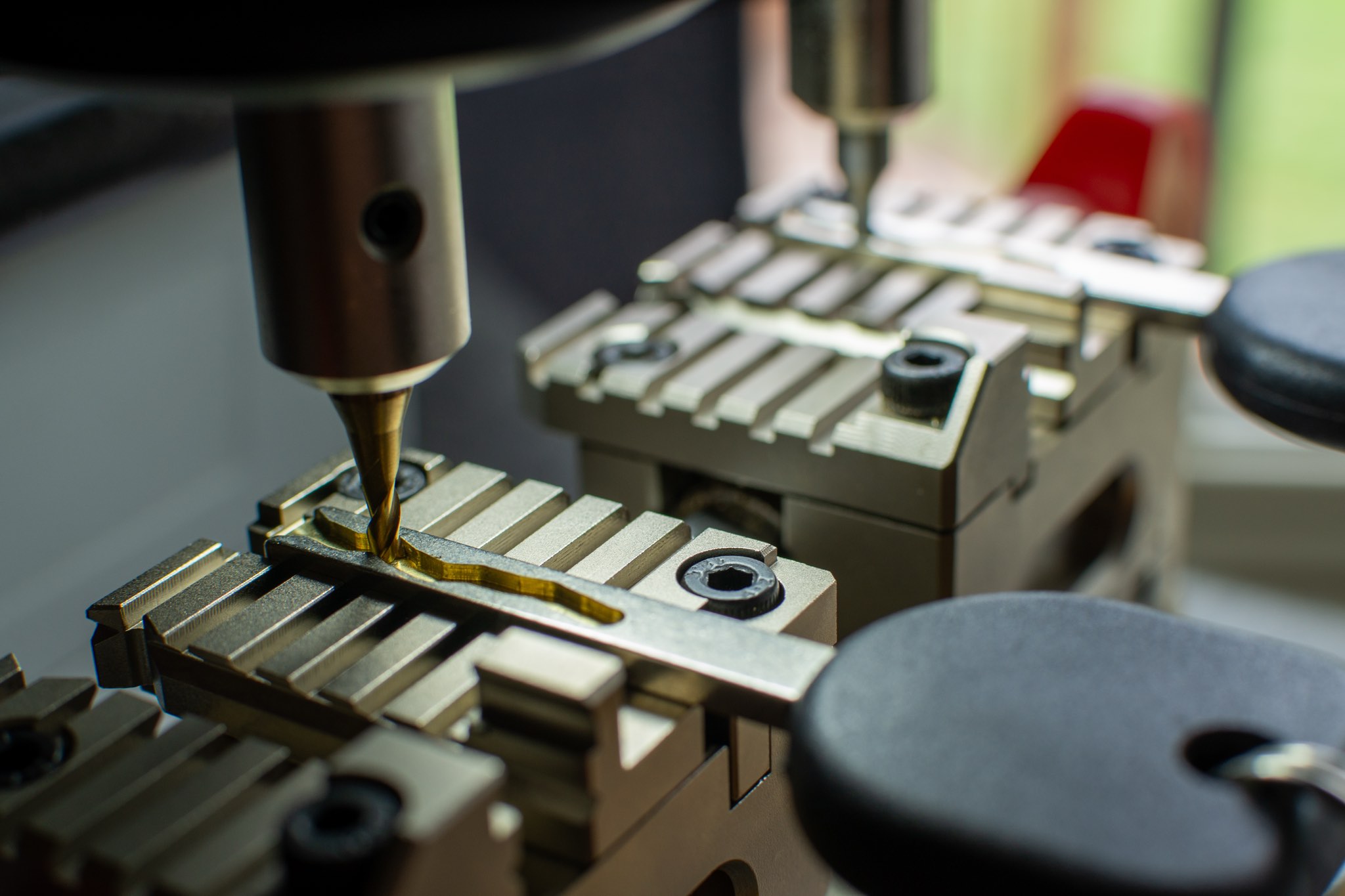 Close view of a duplicate key being cut on a machine.